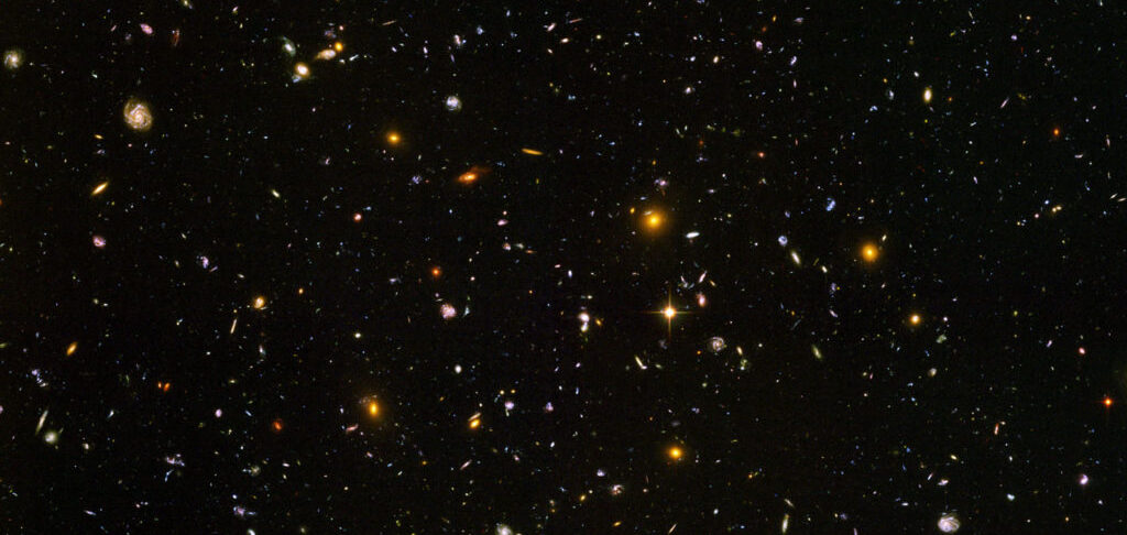 Galaxies, galaxies everywhere - as far as the NASA/ESA Hubble Space Telescope can see. This view of nearly 10,000 galaxies is the deepest visible-light image of the cosmos. Called the Hubble Ultra Deep Field, this galaxy-studded view represents a "deep" core sample of the universe, cutting across billions of light-years. The snapshot includes galaxies of various ages, sizes, shapes, and colours. The smallest, reddest galaxies, about 100, may be among the most distant known, existing when the universe was just 800 million years old. The nearest galaxies - the larger, brighter, well-defined spirals and ellipticals - thrived about 1 billion years ago, when the cosmos was 13 billion years old. In vibrant contrast to the rich harvest of classic spiral and elliptical galaxies, there is a zoo of oddball galaxies littering the field. Some look like toothpicks; others like links on a bracelet. A few appear to be interacting. These oddball galaxies chronicle a period when the universe was younger and more chaotic. Order and structure were just beginning to emerge. The Ultra Deep Field observations, taken by the Advanced Camera for Surveys, represent a narrow, deep view of the cosmos. Peering into the Ultra Deep Field is like looking through a 2.5 metre-long soda straw. In ground-based photographs, the patch of sky in which the galaxies reside (just one-tenth the diameter of the full Moon) is largely empty. Located in the constellation Fornax, the region is so empty that only a handful of stars within the Milky Way galaxy can be seen in the image. In this image, blue and green correspond to colours that can be seen by the human eye, such as hot, young, blue stars and the glow of Sun-like stars in the disks of galaxies. Red represents near-infrared light, which is invisible to the human eye, such as the red glow of dust-enshrouded galaxies. The image required 800 exposures taken over the course of 400 Hubble orbits around Earth. The total amount of exposure time was 11.3 days, taken between Sept. 24, 2003 and Jan. 16, 2004.
